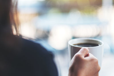 Close-up of hand holding coffee cup