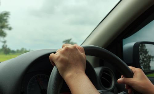 Close-up of hand holding steering wheel