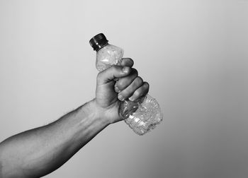 Hand squeezing plastic bottle representing recycling