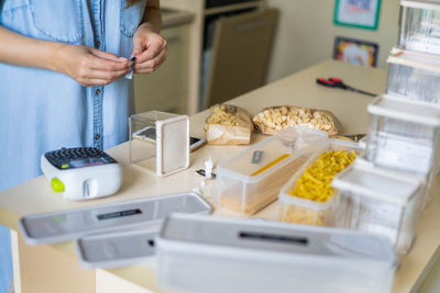 Cropped hands of woman labeling container