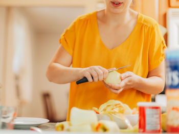 Midsection of woman holding food at home