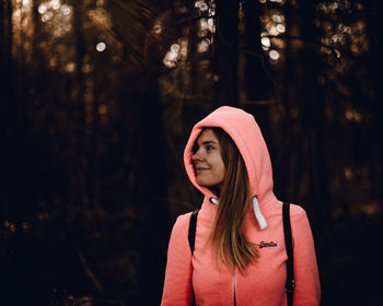 Portrait of beautiful young woman standing in forest