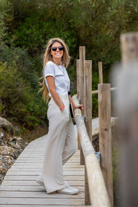 Portrait of young woman standing on footbridge