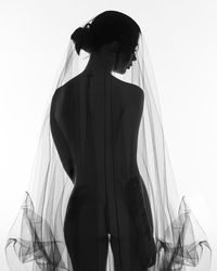 Rear view of woman standing against white background