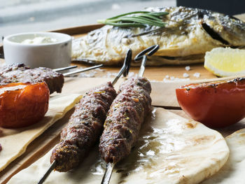 Close-up of fresh shish kebab lamb meat on skewers and fish