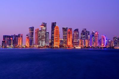 Illuminated cityscape against sky at night