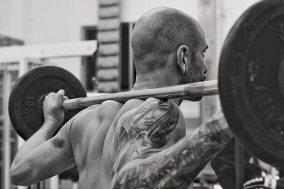 Man exercising with barbell in gym