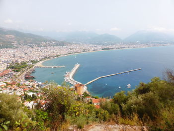 High angle view of city by sea against sky