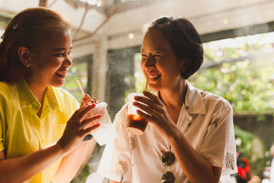 Happy female couple having break with coffee drink in cafe.