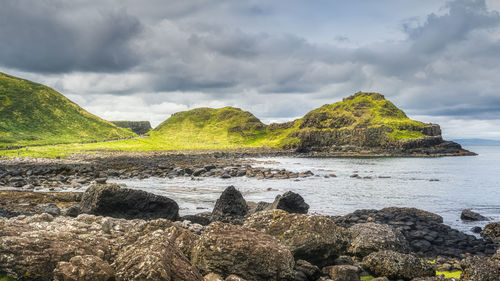 Scenic view of rocks on beach against sky