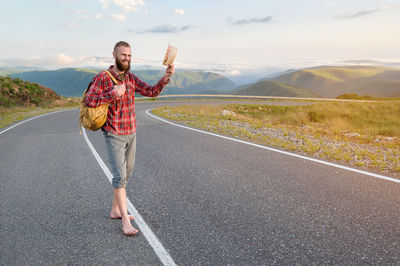 Smiling bearded friendly caucasian man in a shirt and shorts with a backpack 