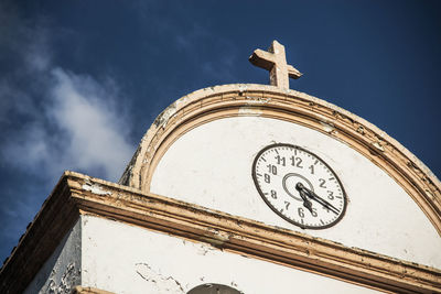 Low angle view of clock on building against sky