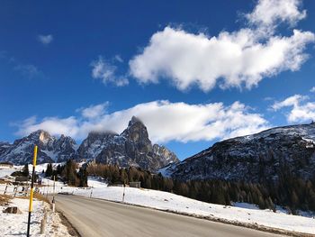 Road by snowcapped mountains against sky