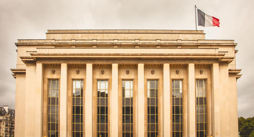 Low angle view of office building against cloudy sky