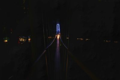 Light trails on bridge over river at night