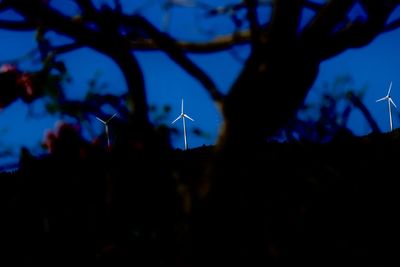 Close-up of silhouette wind turbine against sky