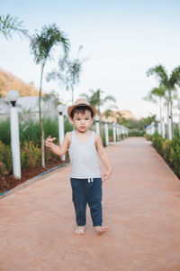 Portrait of boy standing against trees and plants