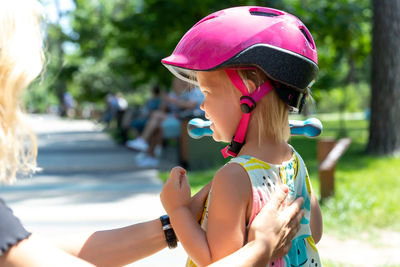 Mother consoling daughter wearing sports helmet