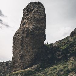 Low angle view of cliff against sky