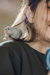 Side view of young woman feeding bird