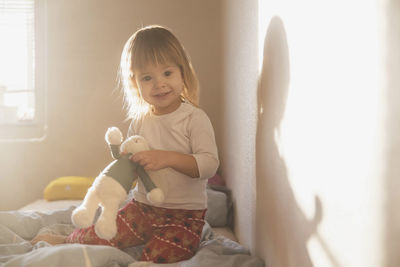 Portrait of cute girl sitting on sofa at home