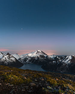 Scenic view of snowcapped mountains against sky at night