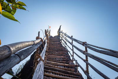 Traditional bamboo stairs leading to the bright blue sky from low angle 