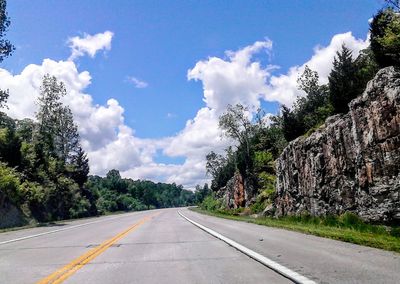 Empty road with trees in background