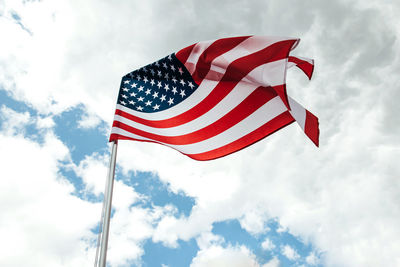 Usa america flag waving in the wind over cloudy sky low angle view.