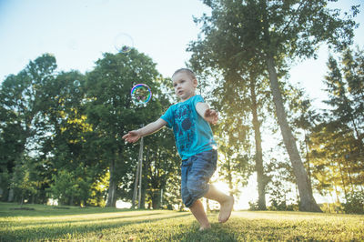 Full length of boy playing with bubbles at park