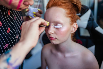 Close-up woman make-up artist doing makeup model