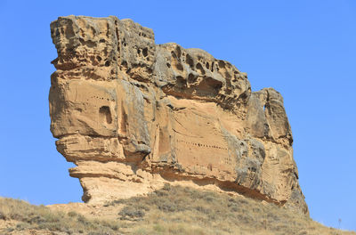 Low angle view of rock formation against blue sky