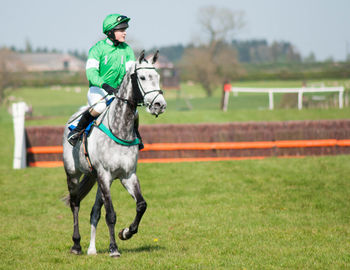 Person rideing horse on grassy field