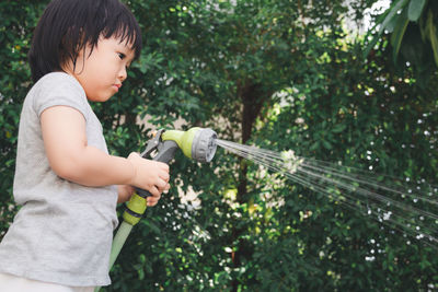Side view of boy holding plants