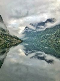 Scenic view of sea and mountains against sky