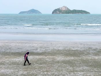 Man standing on beach against clear sky