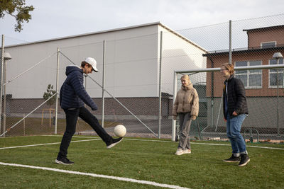 Friends playing soccer on school soccer field