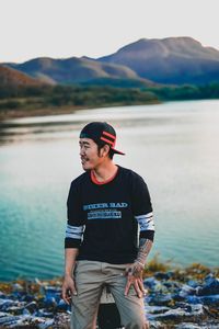 Full length of man standing on lake against mountains