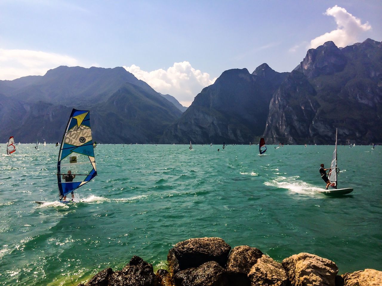 mountain, water, transportation, nautical vessel, mode of transport, sky, boat, mountain range, scenics, sea, beauty in nature, tranquility, tranquil scene, nature, rock - object, travel, men, leisure activity, lifestyles