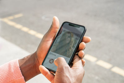 Mid adult man holding smart phone during video call on sunny day