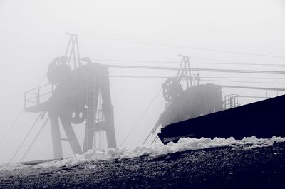 Cable car station against sky in foggy weather