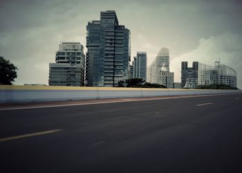 View of city street against cloudy sky