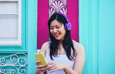 Portrait of smiling young woman using mobile phone