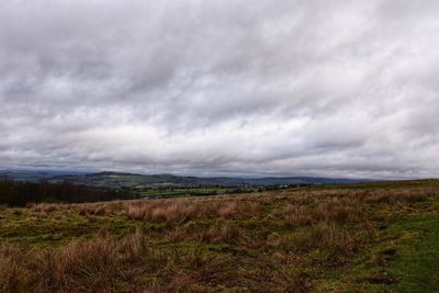 Scenic view of field against cloudy sky