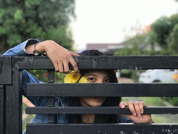 Portrait of a woman playing on railing