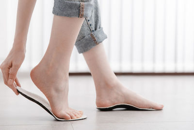 Low section of woman standing on hardwood floor