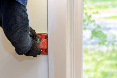 Close-up of man working on door at home