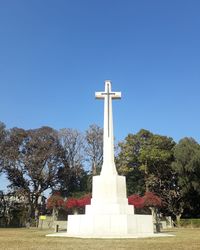 View of cross in cemetery against clear sky