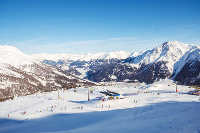 Scenic view of snowcapped mountains against blue sky