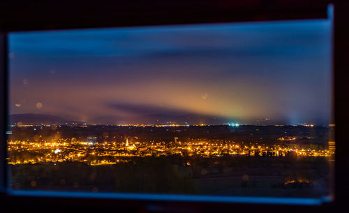 High angle view of illuminated buildings against sky at night